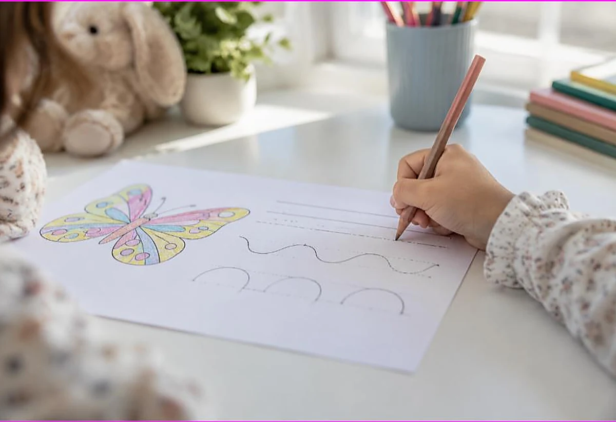 Child tracing pre-writing line and curve strokes with a pencil beside a colored butterfly, coloring and handwriting readiness