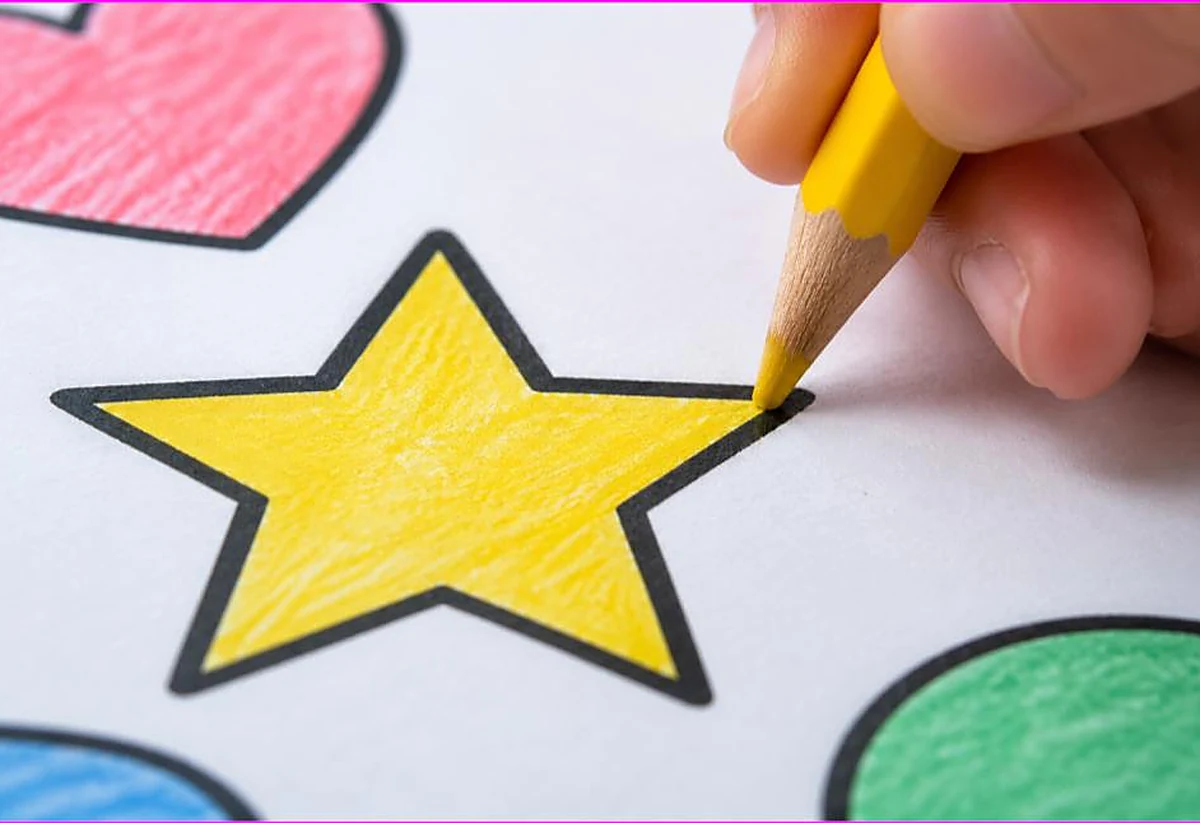 Close-up of a hand neatly coloring a star right up to the black outline with a colored pencil, how to color neatly and stay in the lines