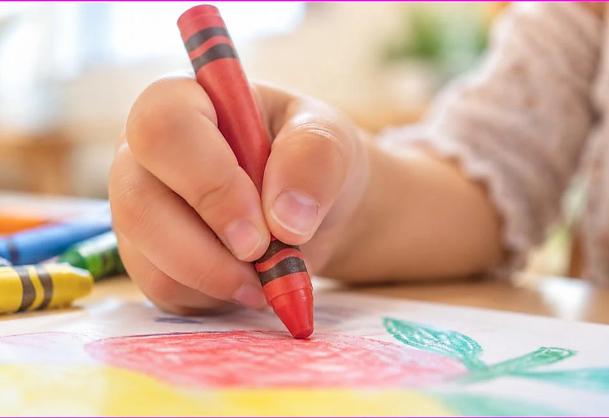 Close-up of a child correct tripod grip on a crayon while coloring, the proper way to hold a crayon